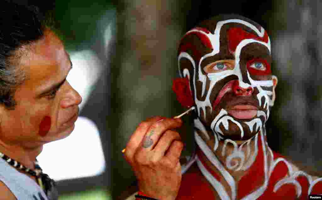 An artist touches up makeup on a model during the &quot;World Bodypainting Festival 2017&quot; in Klagenfurt, Austria.