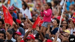 Partidarios del presidente de Venezuela, Nicolás Maduro, sostienen a una niña en el acto de cierre de campaña en Caracas el jueves, 17 de mayo, de 2018.
