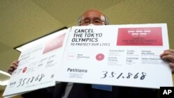 Pengacara Kenji Utsunomiya, perwakilan dari kelompok anti-Olimpiade, menunjukkan petisi online yang menyerukan agar Olimpiade Tokyo dibatalkan, dalam konferensi pers di Tokyo. (AP Photo/Eugene Hoshiko)