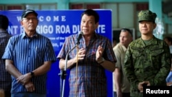 Philippines' President Rodrigo Duterte (C) with Defense Secretary Delfin Lorenzana (L) and General Eduardo Ano, talks after visiting wounded soldiers, at a military camp in Cagayan De Oro, June 11, 2017. 