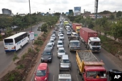 FILE - Drivers sit in queues of traffic on a highway in downtown Nairobi, Kenya, April 14, 2015. Taxi operators want the government to stop operations of ride-sharing app Uber.