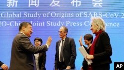 Marion Koopmans, right, and Peter Ben Embarek, center, of the World Health Organization team say farewell to their Chinese counterpart Liang Wannian, left, after a WHO-China Joint Study Press Conference held at the end of the WHO mission in Wuhan, China, 