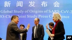 Marion Koopmans, right, and Peter Ben Embarek, center, of the World Health Organization team say farewell to their Chinese counterpart Liang Wannian, left, after a WHO-China Joint Study Press Conference held at the end of the WHO mission in Wuhan, China, 