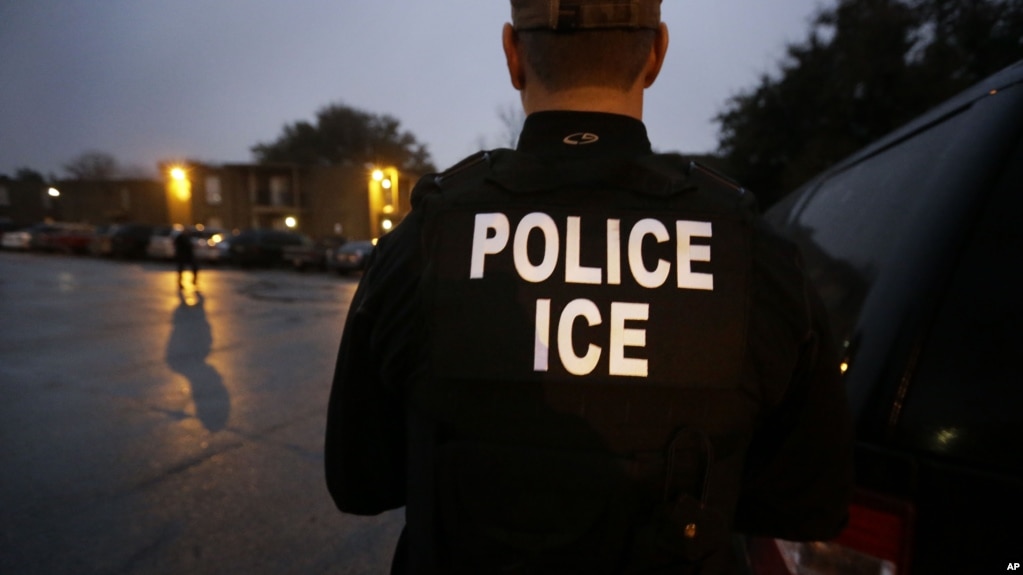 FILE - U.S. Immigration and Customs Enforcement (ICE) agents look for an undocumented immigrant during an early morning raid in Dallas, March 6, 2015. On Friday, agents raided a Tennessee meat processing plant and arrested 97 people.