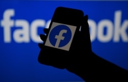 (FILES) In this file photo illustration, a smart phone screen displays the logo of Facebook on a Facebook website background, on April 7, 2021, in Arlington, Virginia