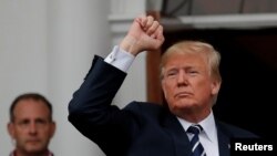 도널드 트럼프 미국 대통령이 지난 11일 뉴저지주 베드민스터에 있는 트럼프 국제골프클럽 앞에서 지지자들 향해 주먹 쥔 손을 들어 보이고 있다. 
