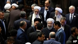 Iran's President Hasan Rouhani, center, leaves the parliament at the end of his swearing-in ceremony for the second term in office, in Tehran, Iran, Saturday, Aug. 5, 2017.