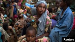 A girl sits at the back of a truck as she prepares to flee sectarian violence in Central African Republic, March 9, 2014. 