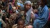 FILE - A girl sits at the back of a truck as she prepares to flee sectarian violence with other Muslim families in a convoy escorted by AU peacekeepers towards the border with Cameroon, in the town of Bouar, Central African Republic, March 9, 2014. 