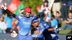Afghanistan’s Hamid Hassan raises his bat in celebration after their Cricket World Cup Pool A win over Scotland in Dunedin, New Zealand, Thursday, Feb. 26, 2015.