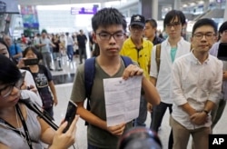 Hong Kong pro-democracy activist Joshua Wong, center, shows the letter from Thailand Immigration office after arriving at Hong Kong airport from Bangkok, Oct. 5, 2016.