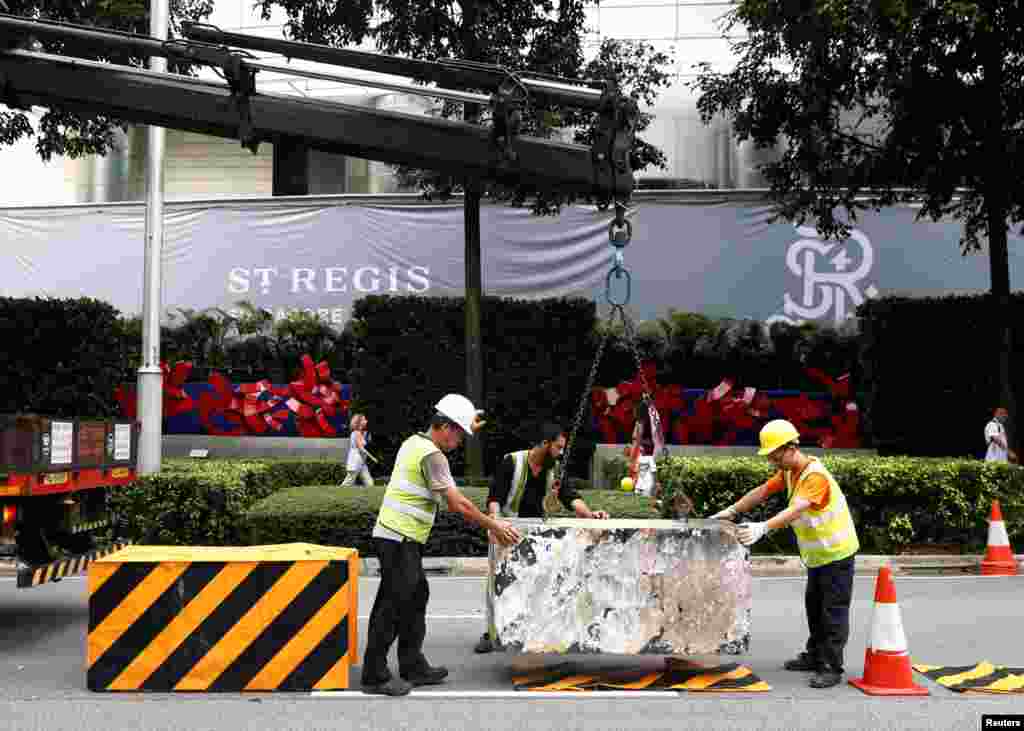 工人在新加坡瑞吉酒店外设置路障（2018年6月9日）。美朝首脑峰会即将举行之际，新加坡当局加强保安，宣布两个峰会相关地点为&ldquo;特别事件专区&rdquo;，一个是圣淘沙岛，另一个在唐林区。当局在唐林区一些道路上设置了混凝土路障。那个区域靠近美国驻新加坡大使馆以及好几个饭店，其中包括美国代表团下榻的香格里拉大酒店。