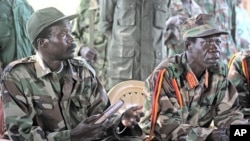 Joseph Kony, the Lord's Resistance Army (LRA) leader, left, and his deputy Vincent Otti, sit inside a tent at Ri-Kwamba in Southern Sudan. (Nov. 2006 file photo)