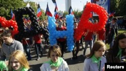 People take part in a procession during celebrations marking the fourth anniversary of self-declared independence in Donetsk, Ukraine May 11, 2018. Translated, the balloons read "DNR," for the Donetsk People’s Republic. 