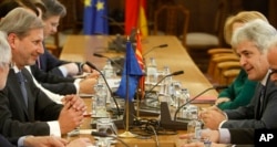 European Union's enlargement commissioner Johannes Hahn, left, talks with Ali Ahmeti, right, the leader of the main ethnic Albanian party DUI, at the parliament building in Skopje, Macedonia, March 21, 2017.