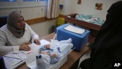 지난 14일 가지지구 내 샤티 난민촌에서 유엔 팔레스타인난민기구(UNRWA)가 운영하는 보건소를 방문한 팔레스타인 여성이 딸 아이의 건강 검진을 받고 있다.