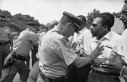 FILE - In this June 7, 1966 file photo, Mississippi police shove the Rev. Martin Luther King and others during a protest march in Mississippi.