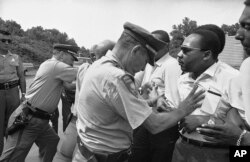 FILE - In this June 7, 1966 file photo, Mississippi police shove the Rev. Martin Luther King and others during a protest march in Mississippi.