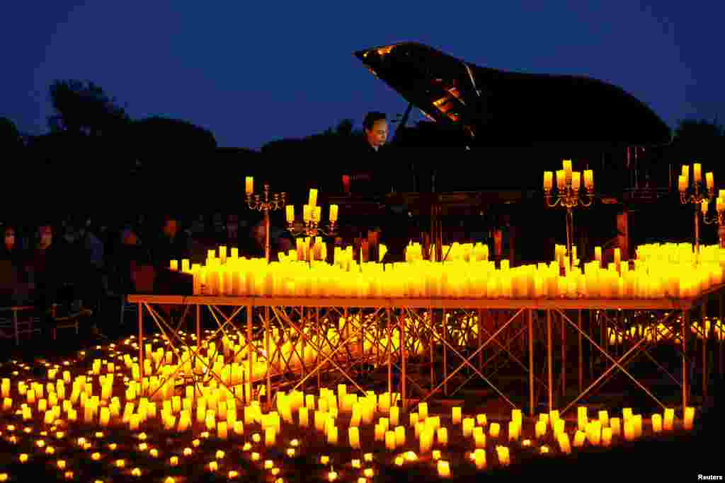 Pianist Giuseppe Califano plays during a candlelight concert inside the archaeological park of Appia Antica in Rome, Italy, May 10, 2021.