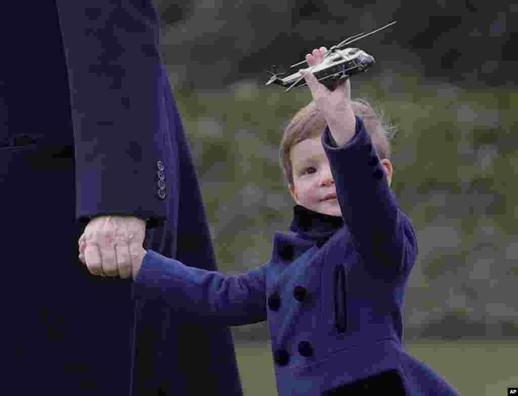 President Donald Trump&#39;s grandson Joseph Kushner holds a model of Marine One, as they walk across the South Lawn of the White House in Washington.