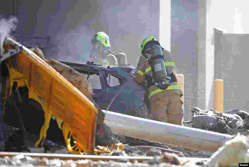 Emergency services personnel are seen at the site of a plane crash in Essendon, in Melbourne, Australia.