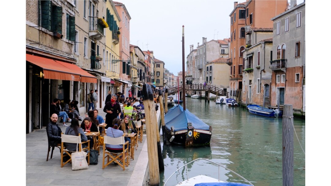 Warga Italia menikmati minuman malam aperitivo sambil duduk di bar di Venesia, Italia, setelah pemerintah setempat menghapus kebijakan karantina di tengah pandemi COVID-19, 26 April 2021.