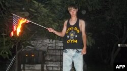 This undated photo taken from Lastrhodesian.com on June 20, 2015, allegedly shows Dylann Roof burning a U.S. flag. The site is no longer in operation. 