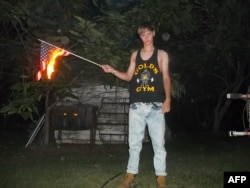 This undated photo taken from Lastrhodesian.com on June 20, 2015, allegedly shows Dylann Roof burning a U.S. flag. The site is no longer in operation.