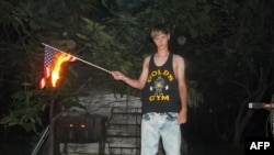This undated photo taken from Lastrhodesian.com on June 20, 2015, allegedly shows Dylann Roof burning a U.S. flag. The site is no longer in operation. 
