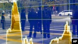 지난 8일 일본 도쿄의 증권회사의 전광판에 증시 현황이 나타나 있다. 국제통화기금(IMF)은 12일 세계 경제성장률 전망을 또 하향 조정했다. (자료사진)
