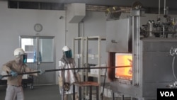 Cambodian workers at Nikko-Kinzokou's factory at the Phnom Penh Special Economic Zone feed molds into a furnace. The factory produces heat-resistant stainless steel baskets to hold and transport auto-parts. (D. de Carteret/VOA)