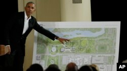 FILE - Former President Barack Obama points to a rendering for the former president's lakefront presidential center at a community event at the South Shore Cultural Center in Chicago, Illinois, May 3, 2017. 