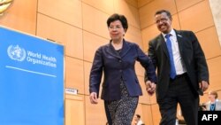 Outgoing Director-general of the World Health Organization (WHO), China's Margaret Chan (L), leads new WHO Director-general, Ethiopia's Tedros Adhanom Ghebreyesus, to the podium after his election during the World Health Assembly (WHA) in Geneva, Switzerland, May 23, 2017.