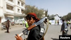 FILE - A Houthi supporter carries a weapon during a gathering in Sanaa, Yemen, April 2, 2020.