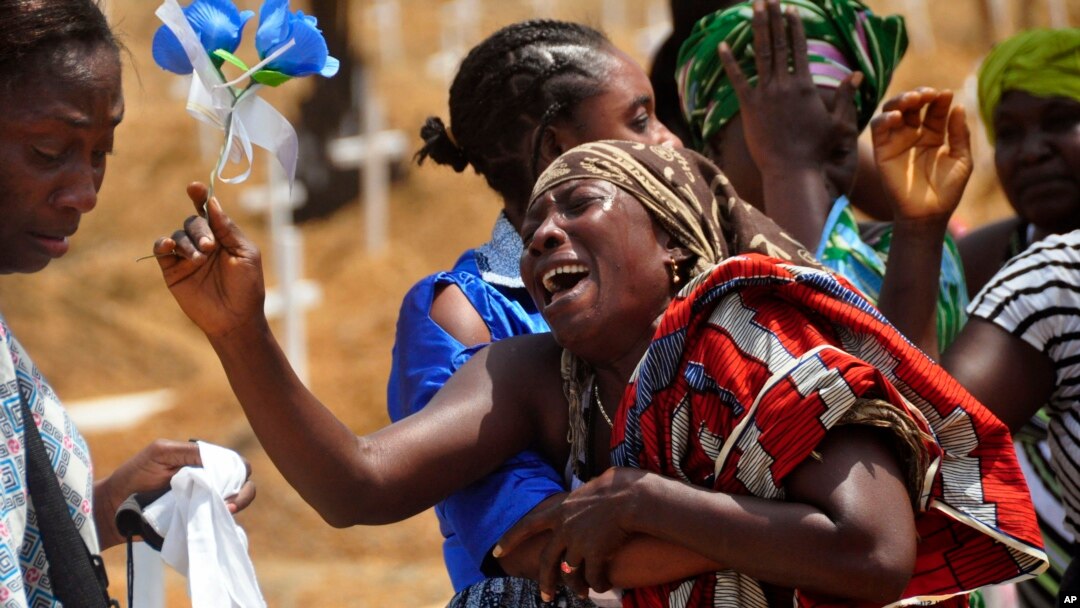 Relatives weep as they bury a loved one suspected of dying from the Ebola virus at a new graveyard on the outskirts of Monrovia, Liberia, March 11, 2015. 