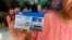 A woman holds up a SIM card, which she won in a June lottery, in Rangoon, Burma, June 24, 2013. 