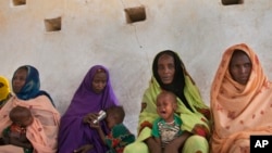 FILE - Mothers wait for their children to be examined for signs of malnutrition at a walk-in nutrition clinic in Barrah, a desert village in the Sahel belt of Chad, April 20, 2012. 