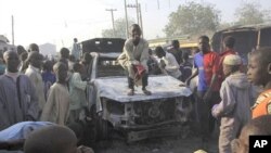 Wani yaro yana tsaye kan motar 'yan sanda aka kona lokacin wani hari kan caji ofis na Sheka a Birnin Kano, 25 Janairu 2012