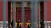 Security guards wearing protective face masks stand guard at the closed gates of the Forbidden City, in Beijing, April 19, 2020.