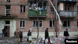 Algunos vecinos sacan sus pertenencias de sus viviendas, destruidas por misiles rusos, en Kiev, el 31 de diciembre de 2022.