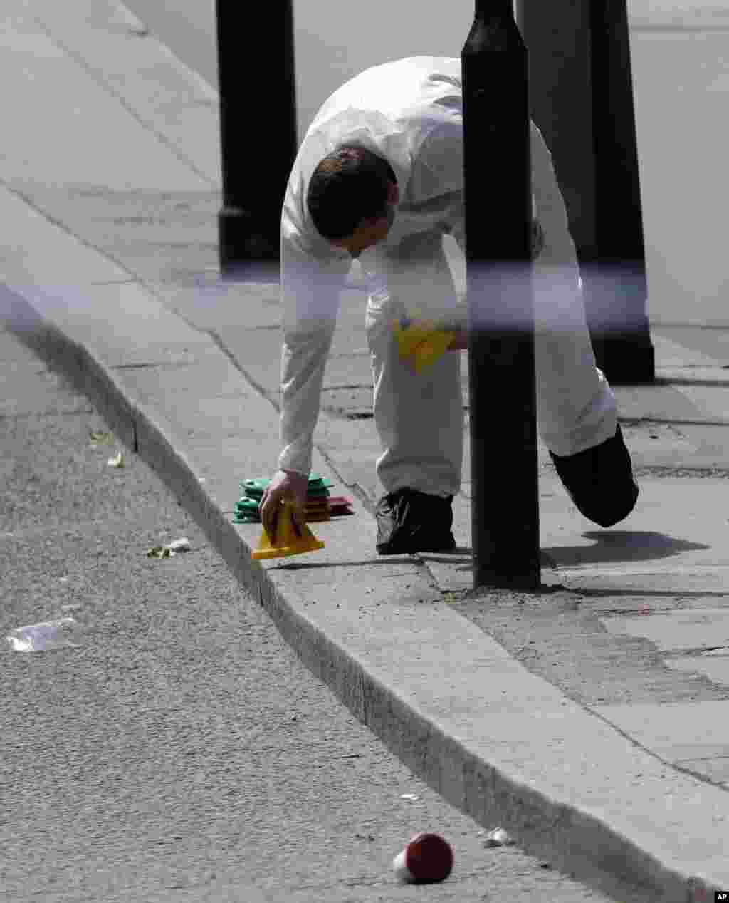 Un guardia forense marca el pavimento dentro de la zona acordonada en el área del Puente de Londres, donde una serie de ataques descritos como terrorismo causaron la muerte a siete personas y dejaron unas 48 heridas. Junio 4, 2017.