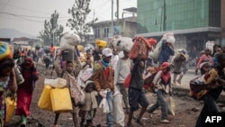 Des habitants transportent leurs biens alors qu'ils fuient Kibati, où les combats se sont intensifiés, en direction de la ville de Goma, le 26 janvier 2025. (Photo Jospin Mwisha / AFP)