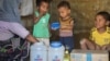 Rohingya children eat from jars with the USAID logo on them, at a refugee camp in Cox's Bazar, Bangladesh, Feb. 11, 2025.