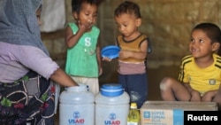 Rohingya children eat from jars with the USAID logo on them, at a refugee camp in Cox's Bazar, Bangladesh, Feb. 11, 2025.