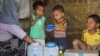 Rohingya children eat from jars with the USAID logo on them, at a refugee camp in Cox's Bazar, Bangladesh, Feb. 11, 2025.