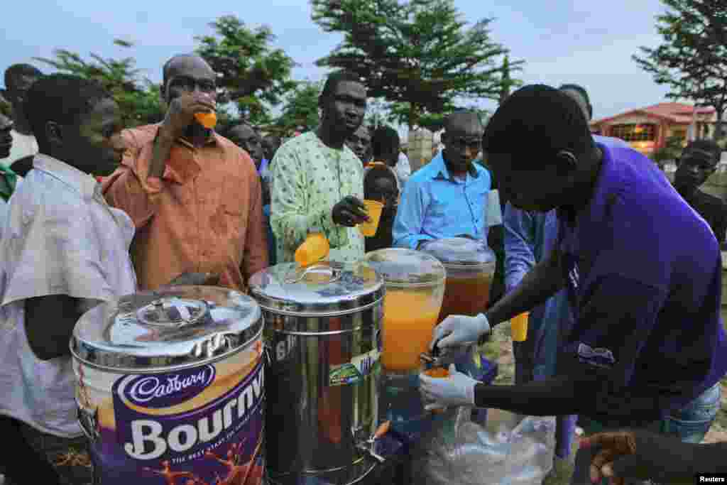 A man serves drinks to others as they break fast during the Islamic holy month of Ramadan at Nasfat Mosque in Utako, Abuja.