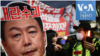 Demonstran membawa poster dengan gambar wajah presiden Korea Selatan Yoon Suk Yeol dalam aksi protes menuntut dilengserkannya Yoon di luar gedung Majelis Nasional di Seoul, pada 8 Desember 2024. (Foto: AFP/Philip Fong)