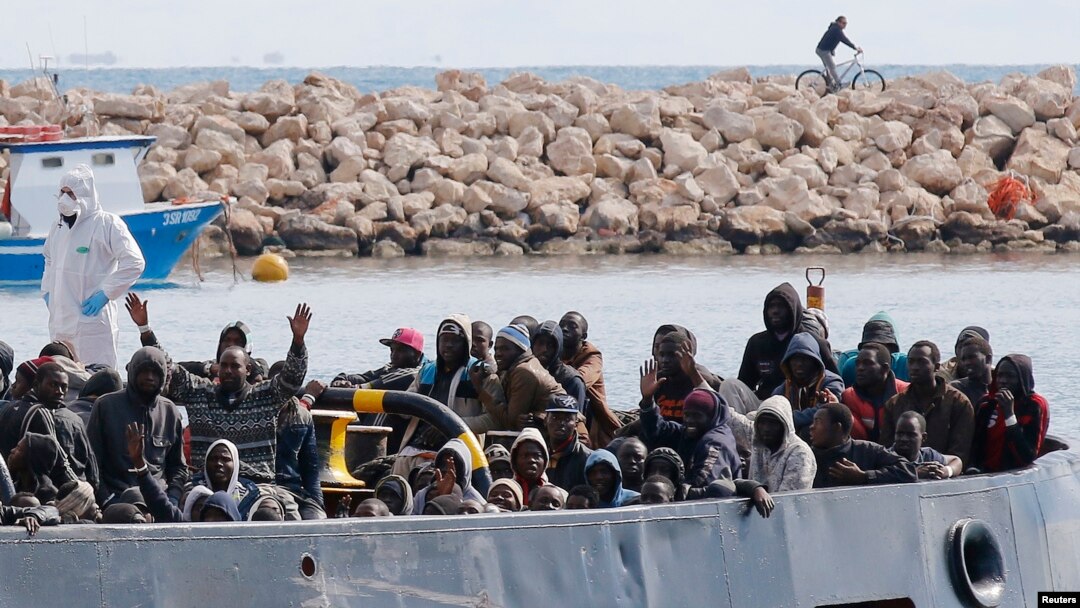FILE - After more than 300 migrants died Friday trying to cross the Mediterranean, other migrants arrived by boat at the Sicilian harbor of Pozzallo, Italy, Feb.15, 2015. 