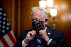 FILE - House Majority Leader Steny Hoyer of Maryland puts his mask on after speaking on Capitol Hill, April 23, 2020.