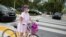 Una mujer utiliza una máscara protectora mientras pasea con su bicicleta por Miami Beach, Florida, el 8 de abril de 2020.